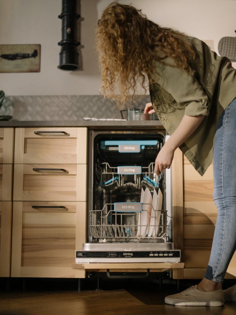 woman putting plates in the dishwasher