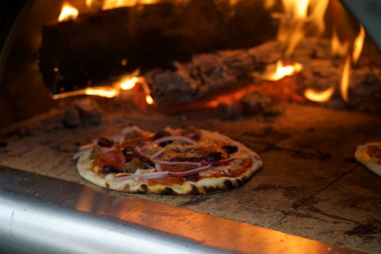 Image of a Pizza cooking in a pizza oven