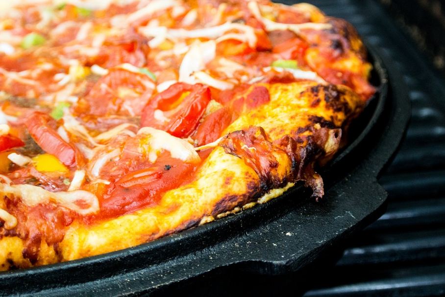 Pan pizza resting on a barbeque grill