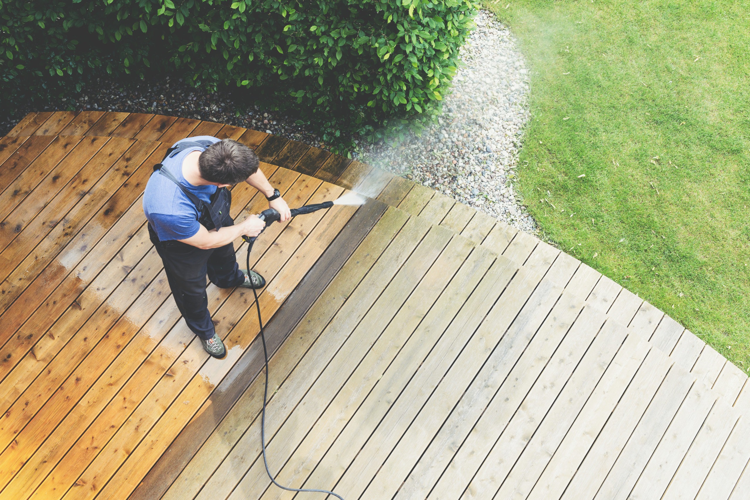man cleaning terrace with a pressure washer