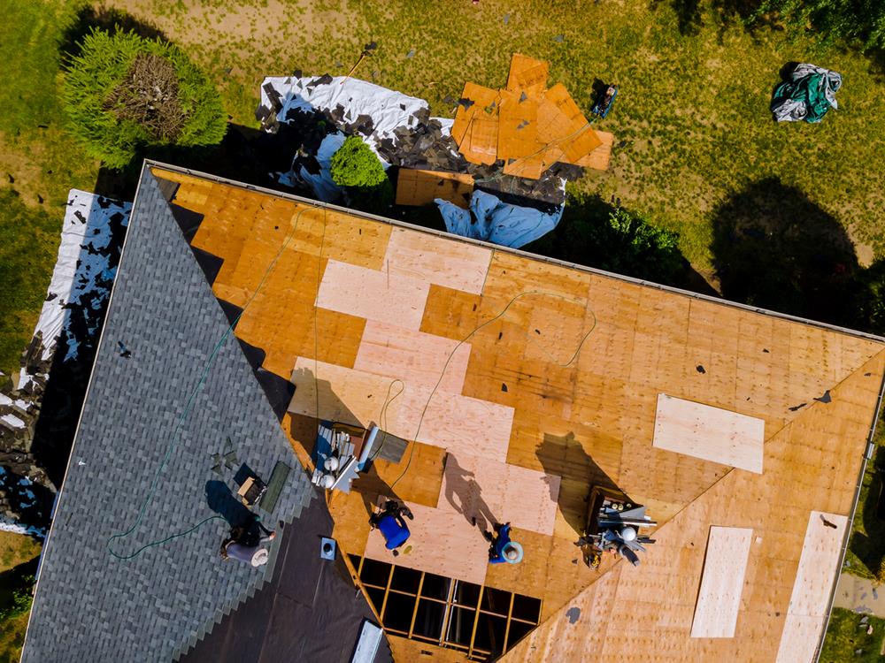 A crew installing roofing for a house