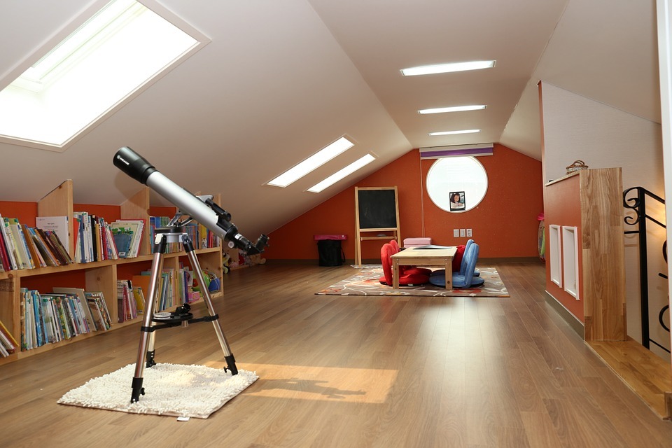 attic, bookshelf, books, telescope, railing, table, cushions, rug, carpet, windows, blackboard, bag, picture frame