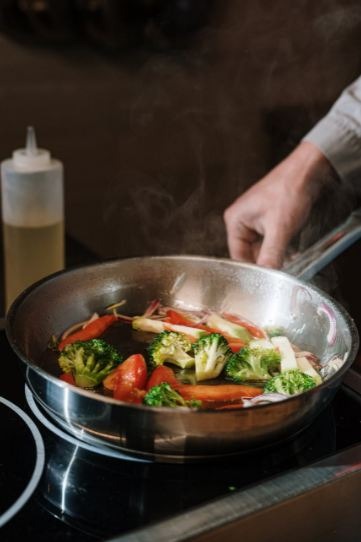 person-holding-black-cooking-pan-with-vegetable-salad