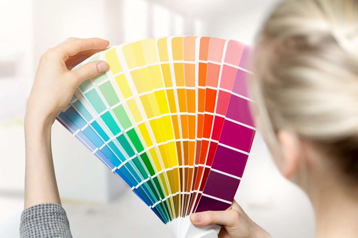 woman choosing paint color from the swatch catalog