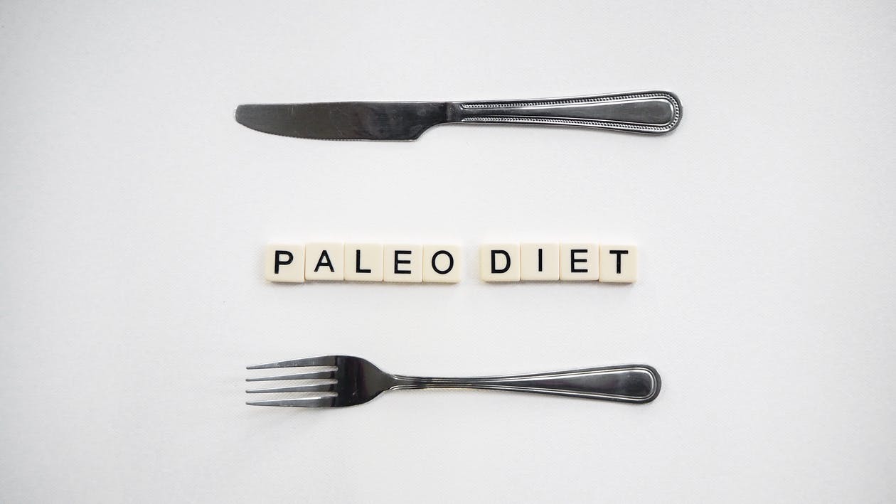 Image showing the word paleo diet written on the shelf with silverware cutlery around it.