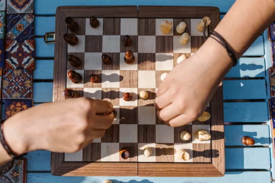 Image showing two hands making the pieces on a chess board.