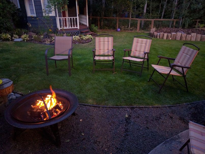 Lawn chairs in front of a fire pit in the backyard