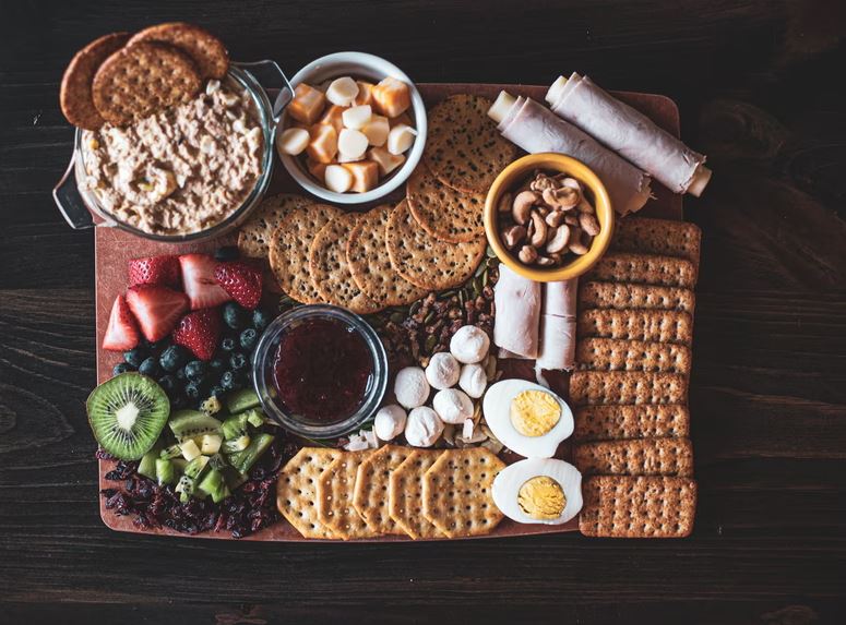 A charcuterie board with whole-wheat and seed-based crackers