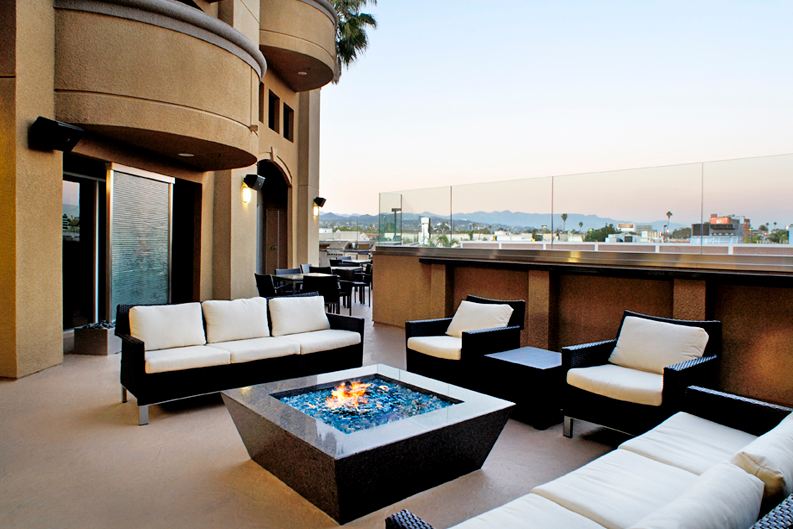 A fire pit table surrounded with patio furniture