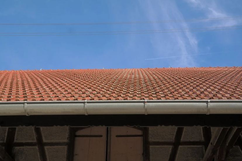 A gutter on a red roof