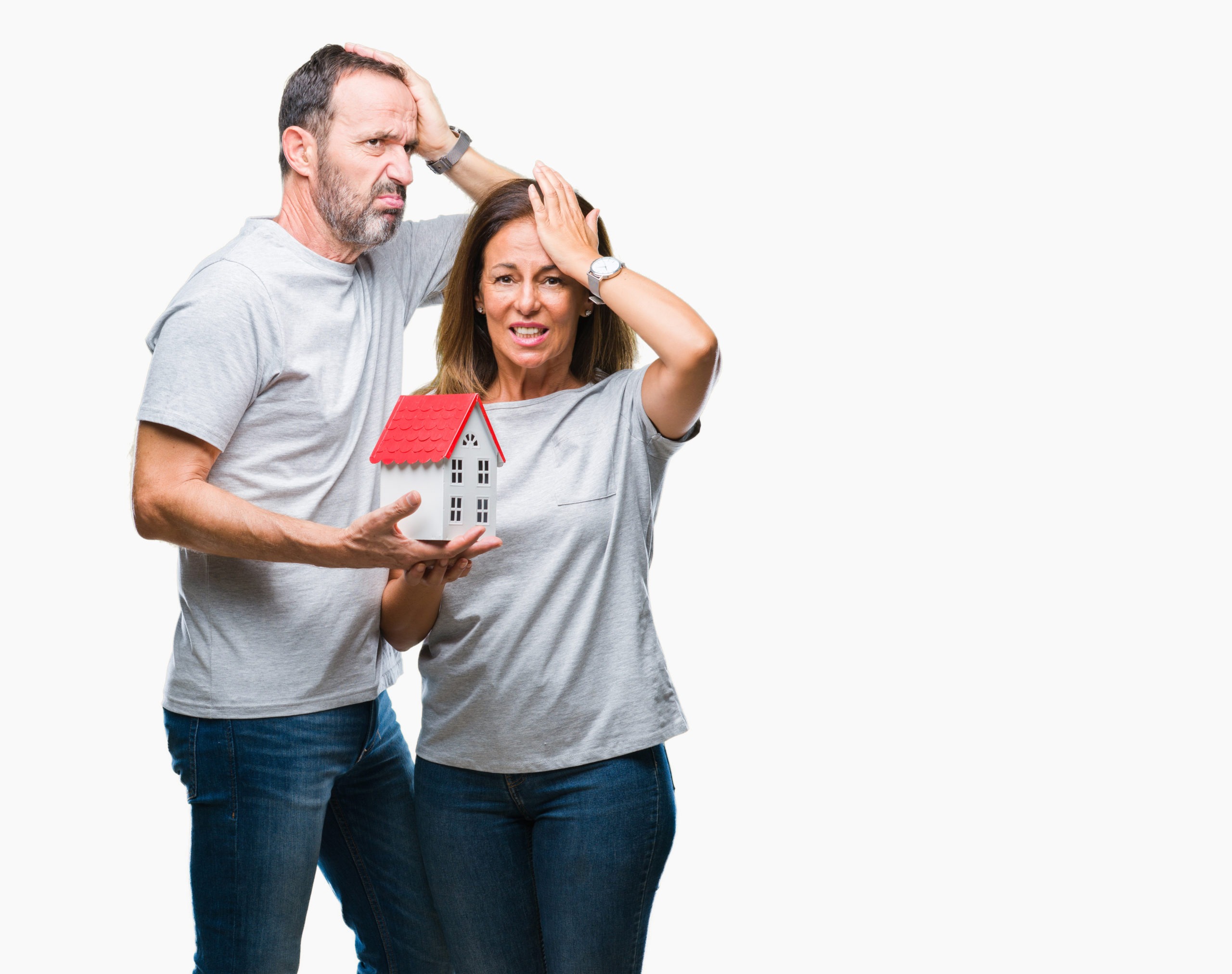 Middle age hispanic casual couple buying new house over isolated background stressed with hand on head, shocked with shame and surprise face, angry and frustrated. Fear and upset for mistake.