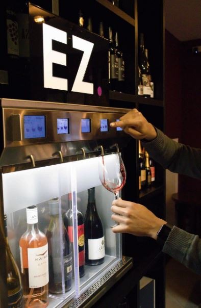 a bartender using a wine dispenser