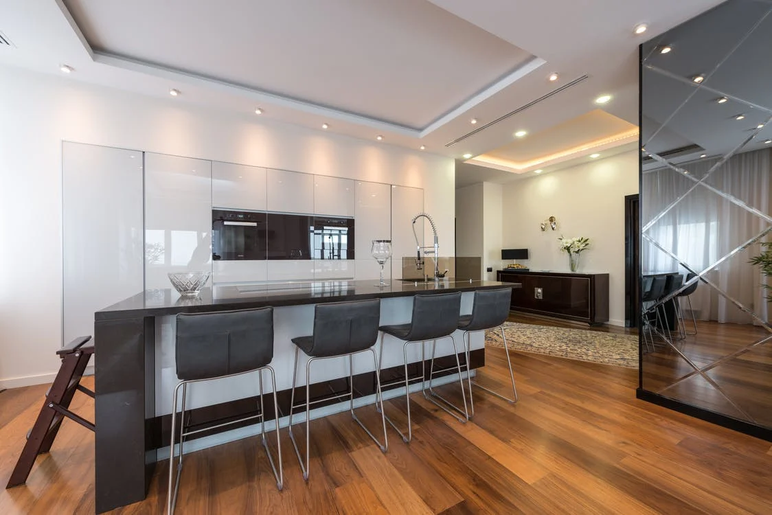 a studio apartment with a modern kitchen zone and suspended ceiling
