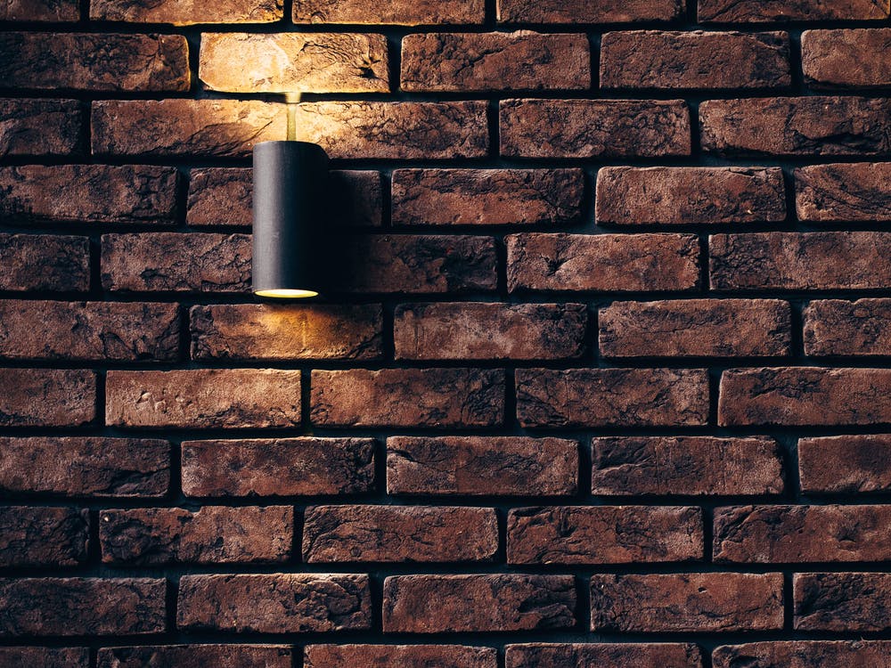 a light fixture on a stone wall