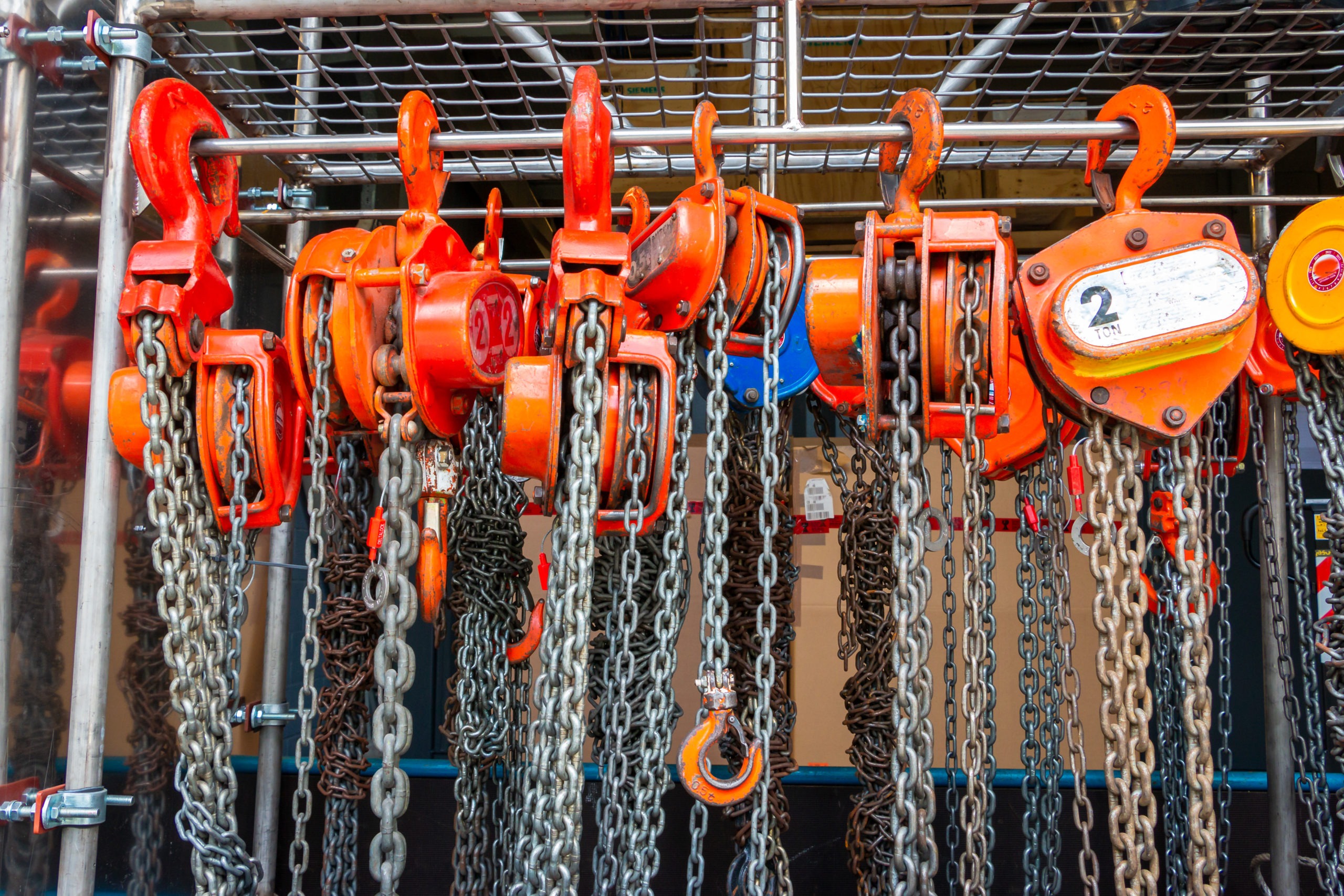 Multiple chain hoists hanging in a rack ready for use in a indus