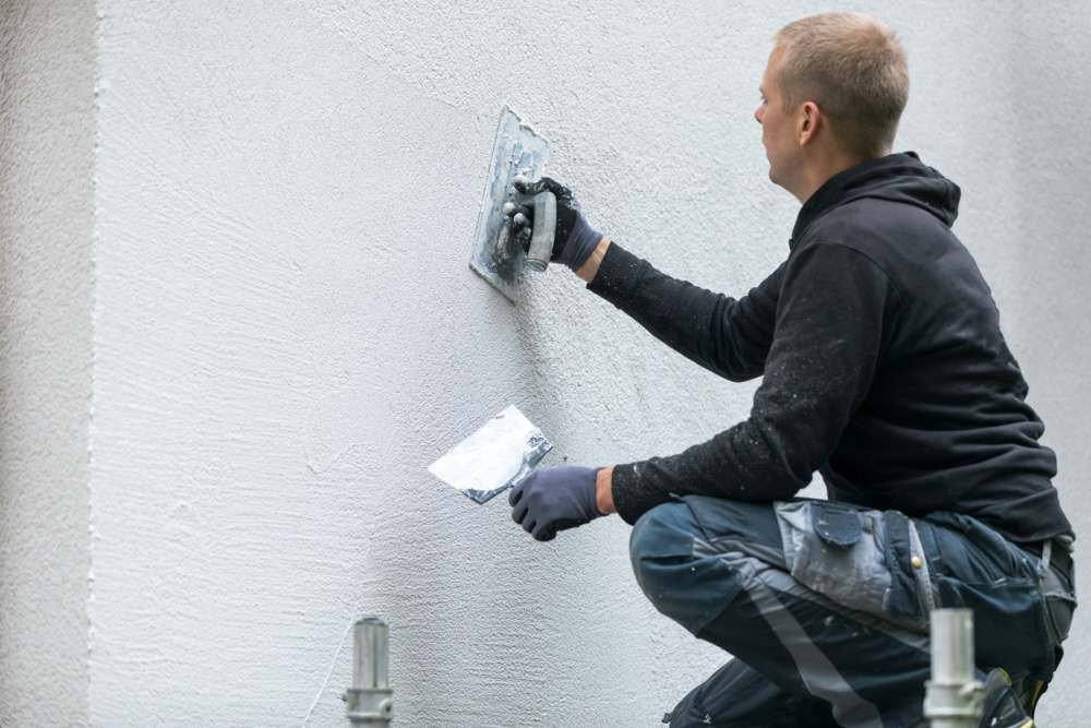 Applying stucco on a wall