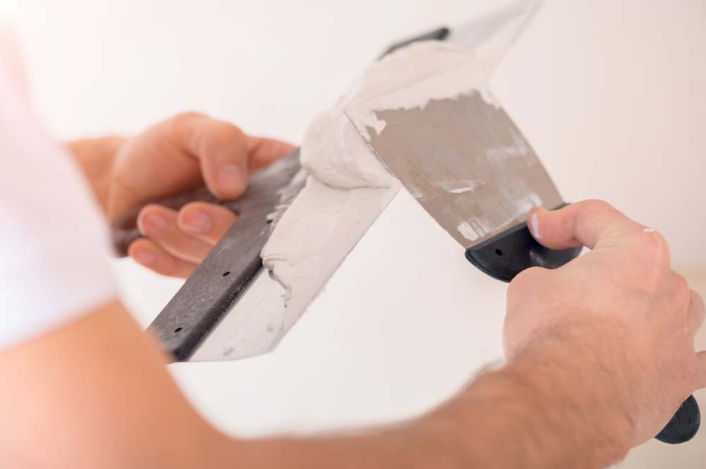 Applying stucco on two spatulas