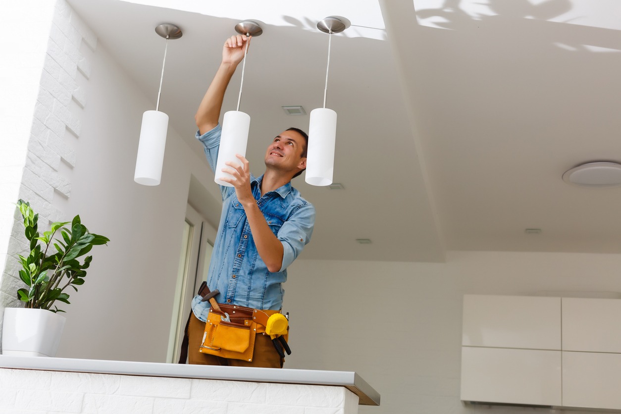 man installing ceiling lights