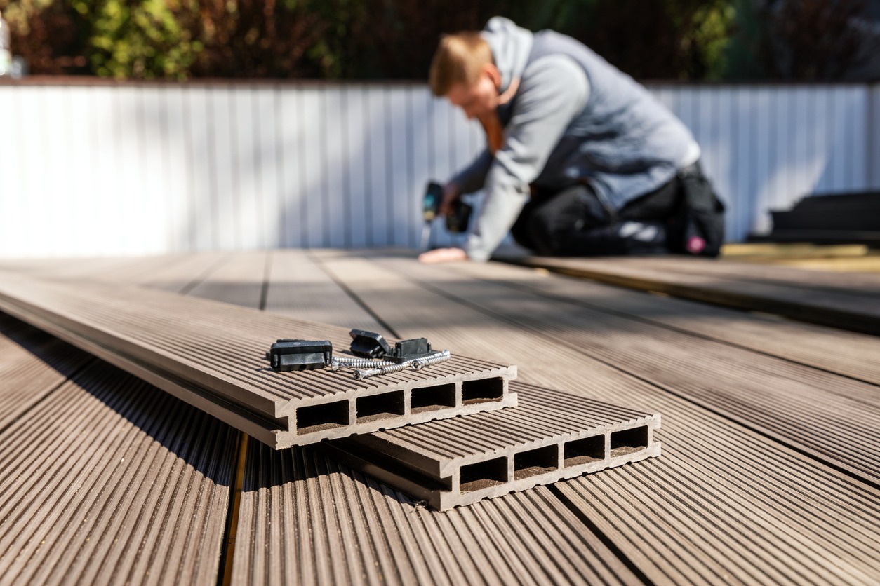 man building a deck using composite material