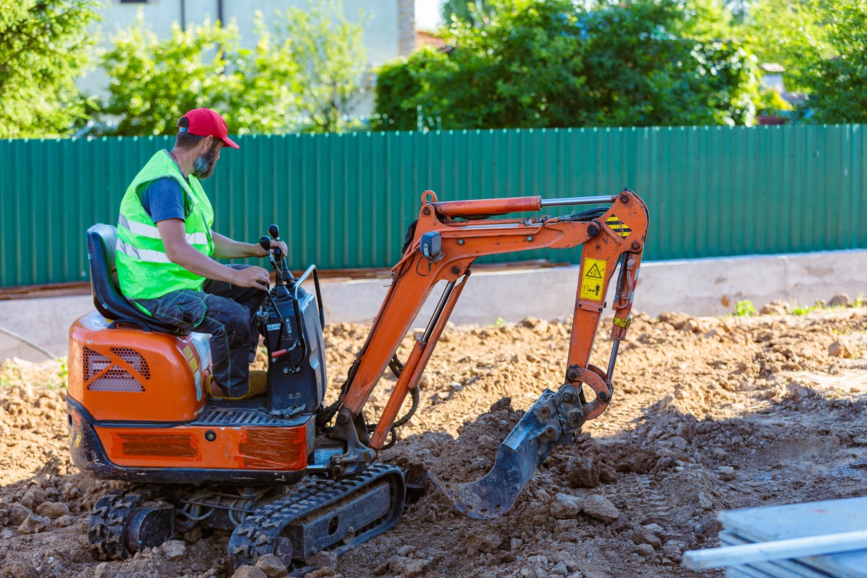 man using a mini excavator