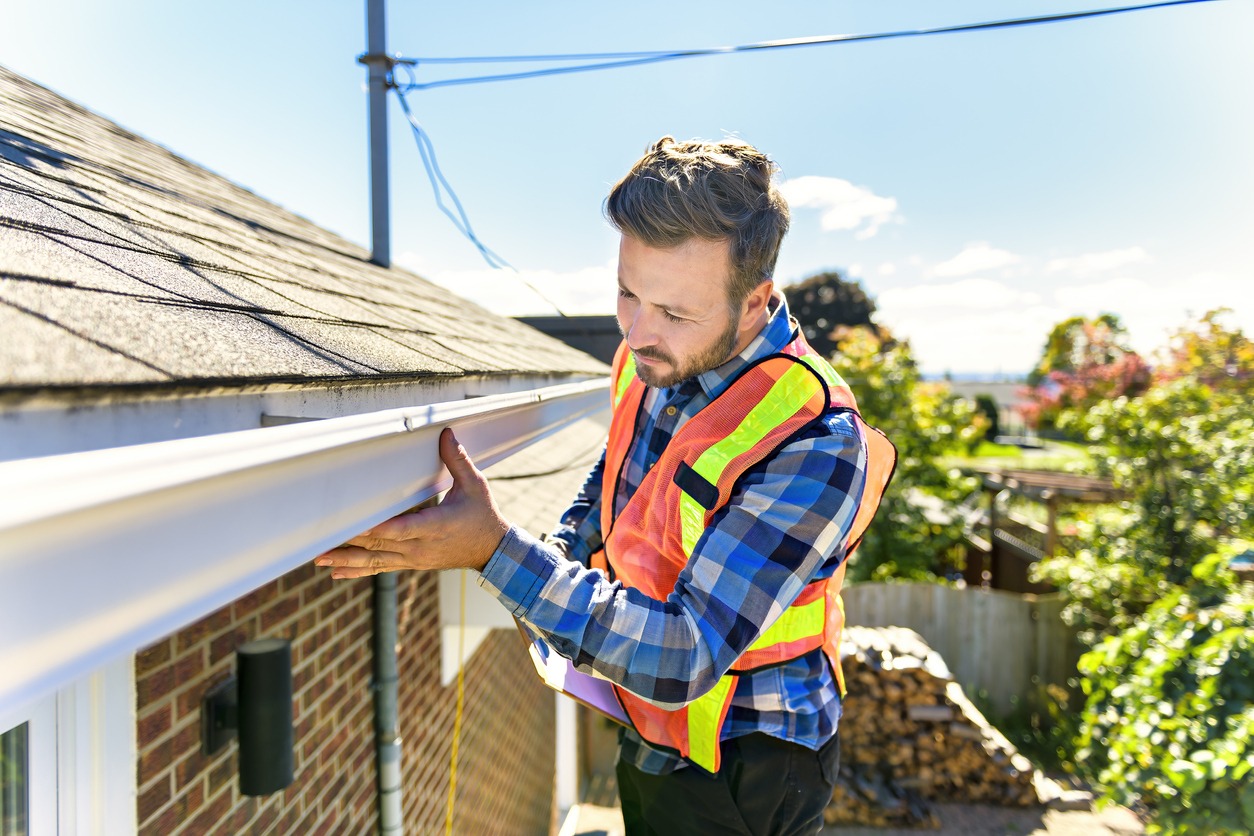 a man inspecting a roof closely