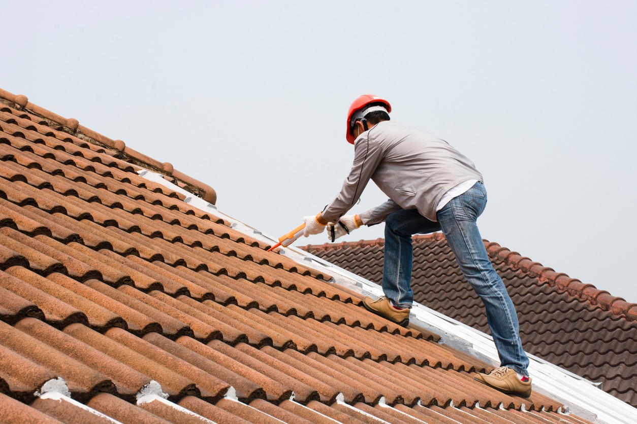 a person using a caulk gun on top of the roof