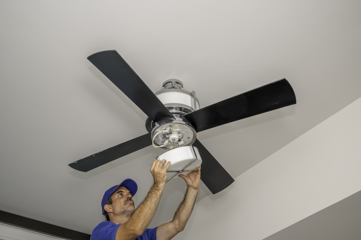 man checking a ceiling fan