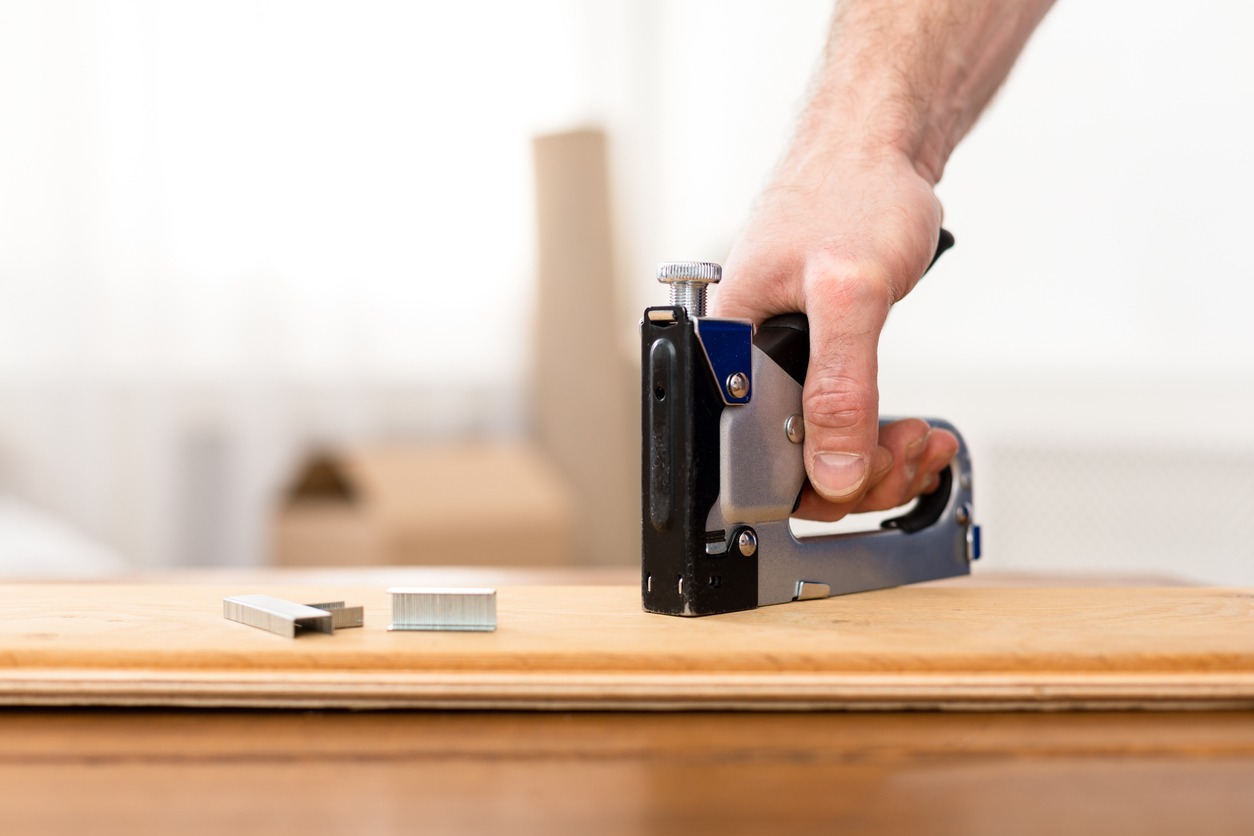 person using a staple gun on wood