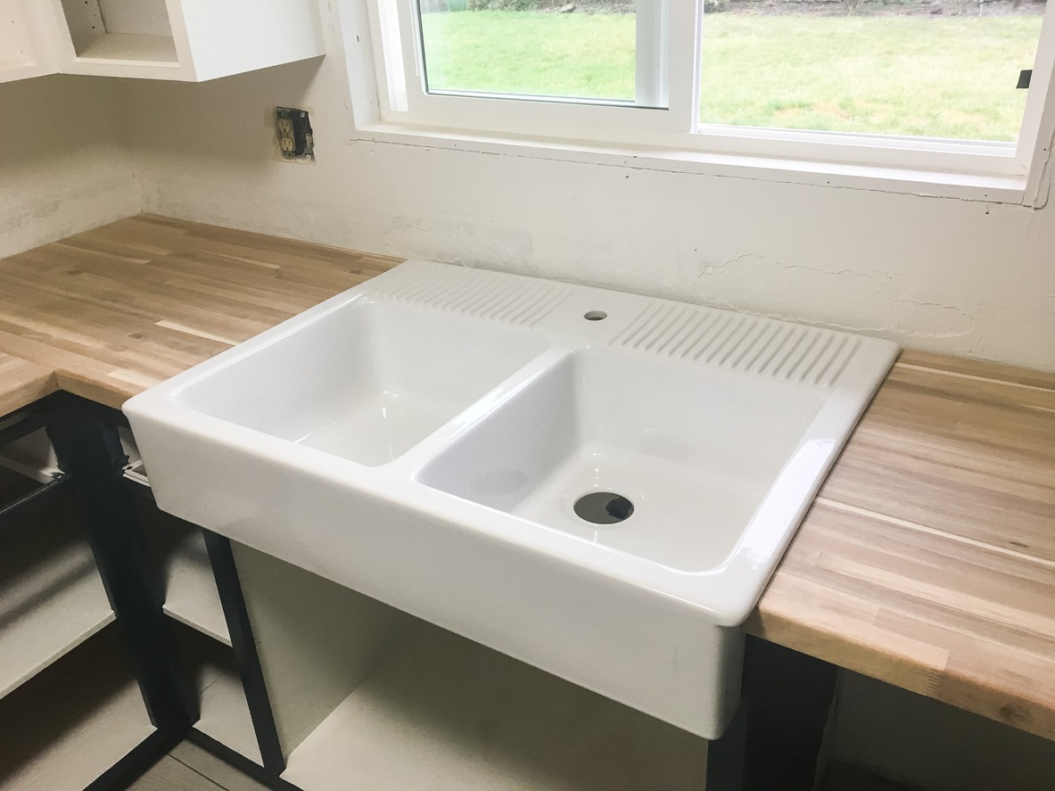 a large farmhouse sink in the kitchen of a full renovation