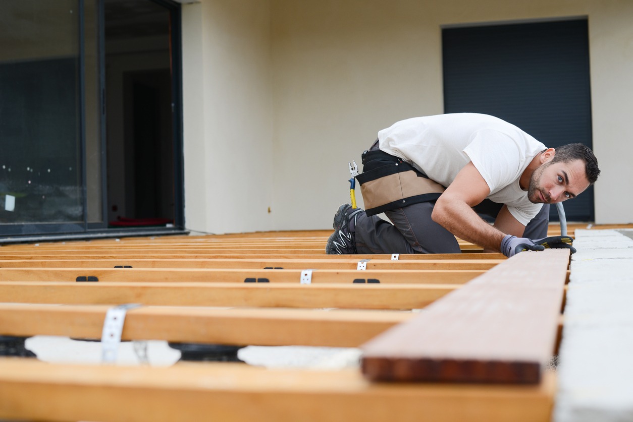 a man installing a wood deck