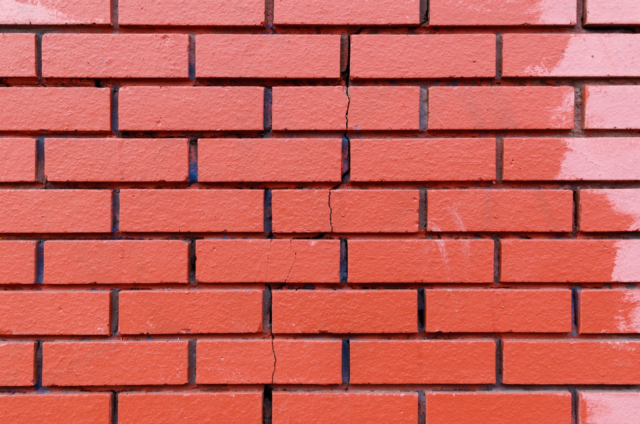 a red brick wall with a vertical crack