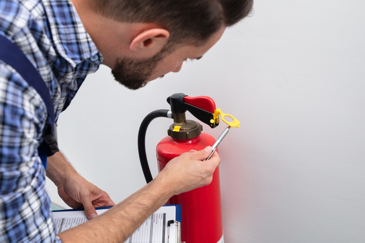 A person checking expiration date of fire extinguisher