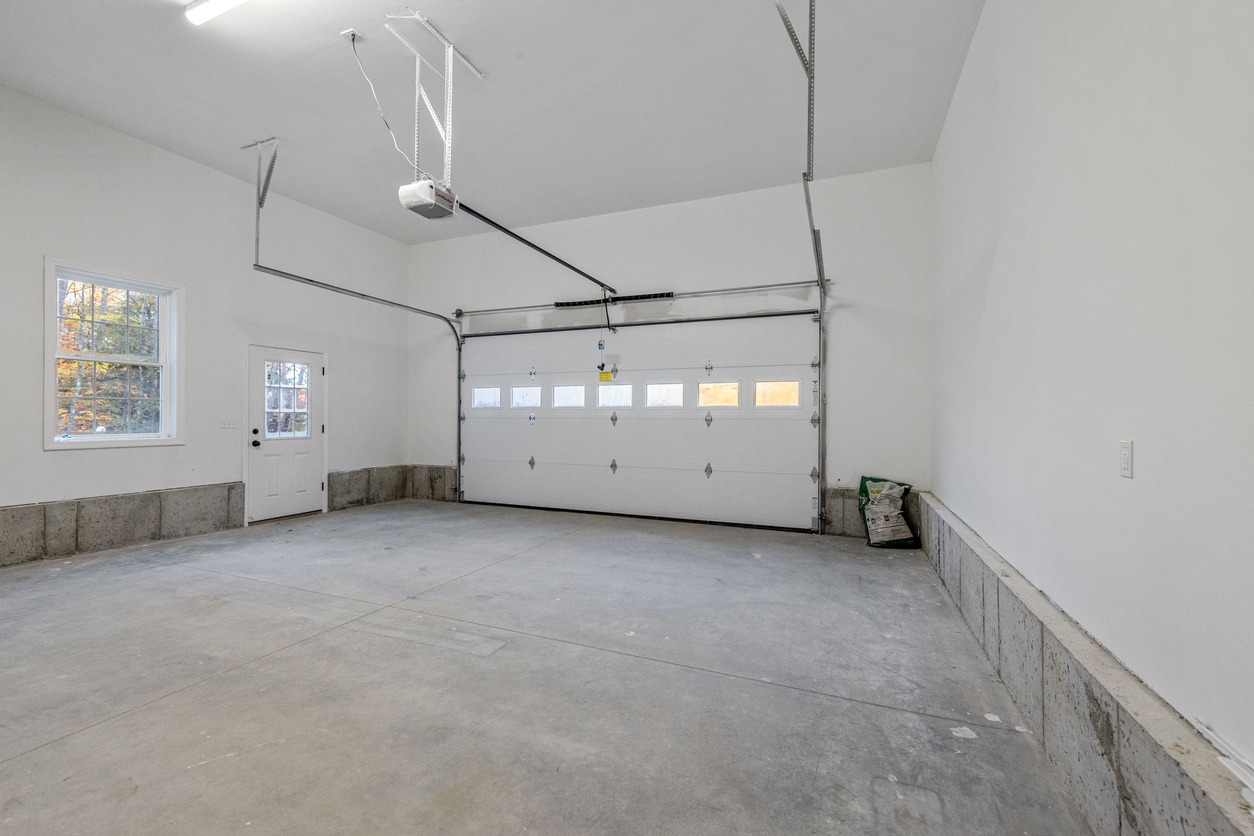 a newly constructed garage with white walls and gray floor
