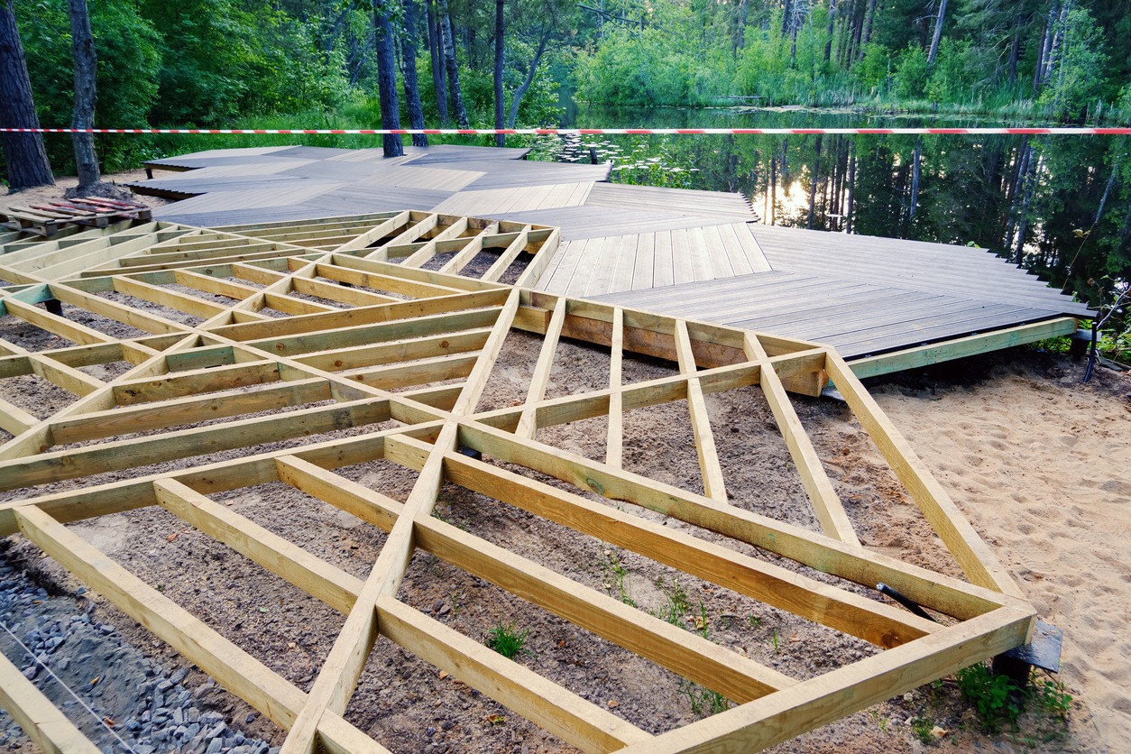 wooden frame deck being built in front of pond