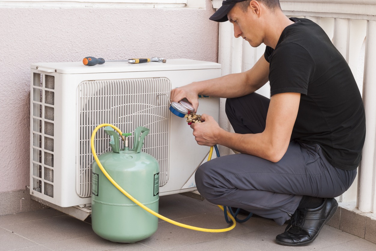 Air conditioning technician checking refrigerant levels