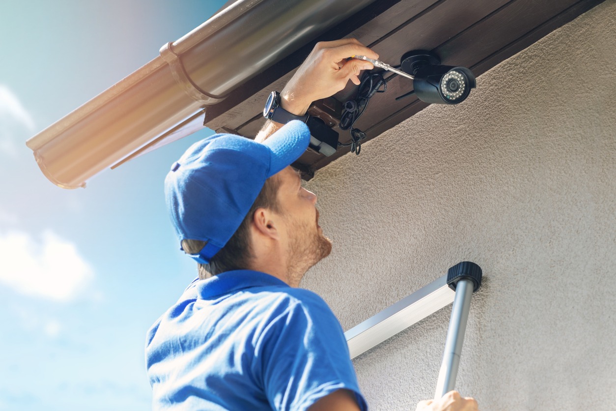 Man installs outdoor surveillance ip camera for home security