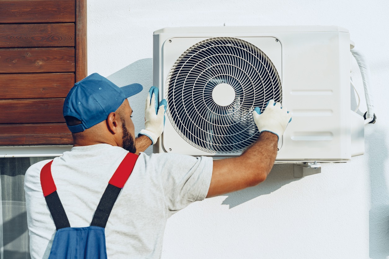 Repairman fixing air conditioner blower
