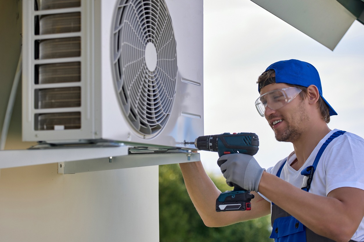 worker installs outer metal case air conditioner 